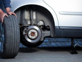 mobile mechanic changing the tire on a car