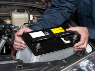 mobile mechanic installing new battery into car