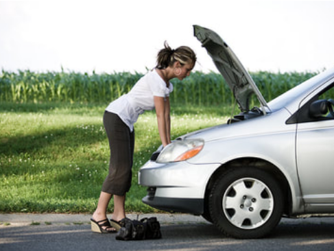 car broken down on the side of the road with the hood up and a girl looking at the engine