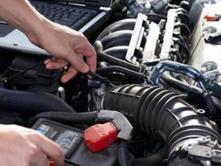 mobile mechanic working on engine of a car